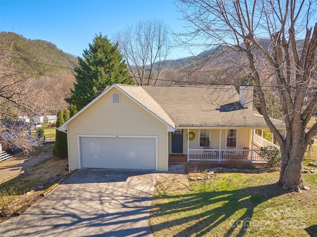 ranch-style home with driveway, covered porch, an attached garage, and a front lawn