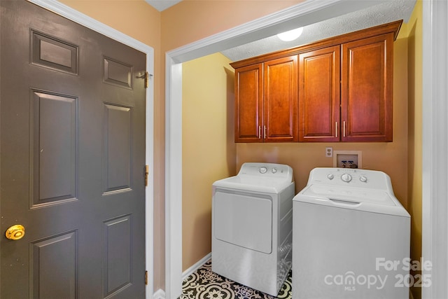 washroom featuring washing machine and dryer, cabinet space, and baseboards