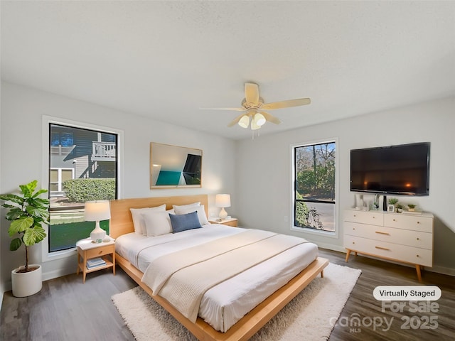 bedroom featuring ceiling fan, baseboards, and wood finished floors