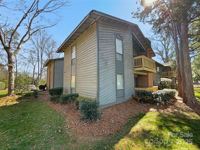 view of property exterior featuring a yard and a balcony