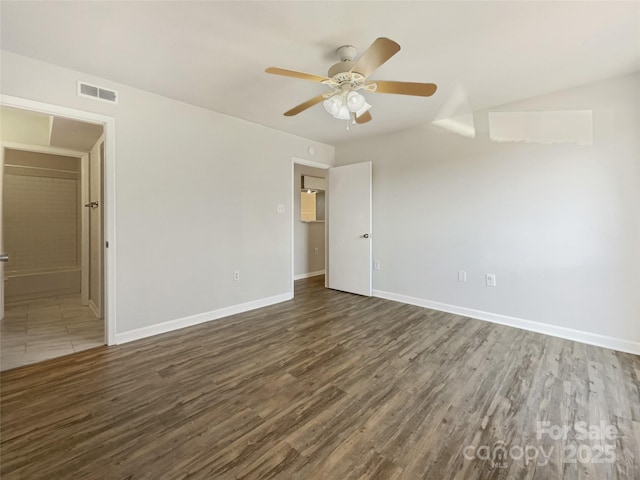 empty room with baseboards, visible vents, ceiling fan, and wood finished floors