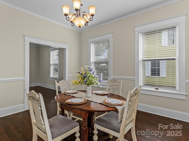 dining space with ornamental molding, wood finished floors, baseboards, and an inviting chandelier