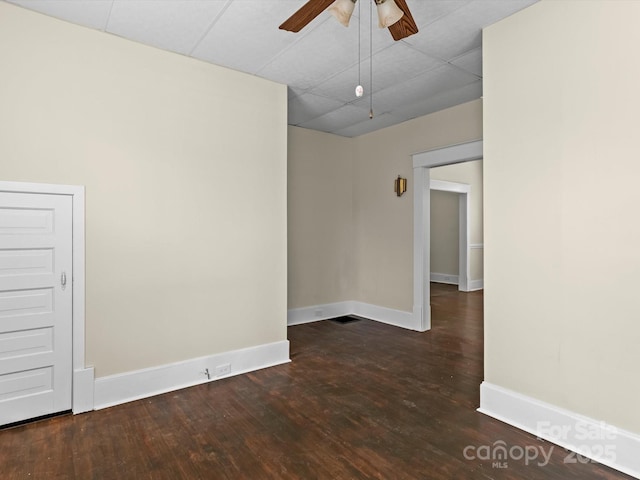 unfurnished room featuring ceiling fan, visible vents, baseboards, and wood finished floors