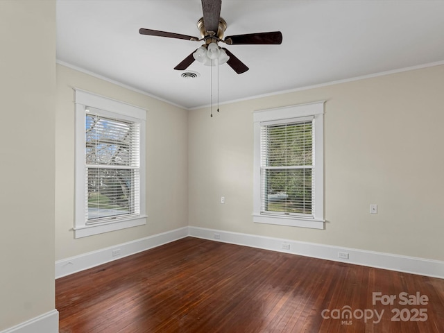 unfurnished room featuring crown molding, hardwood / wood-style flooring, visible vents, and baseboards