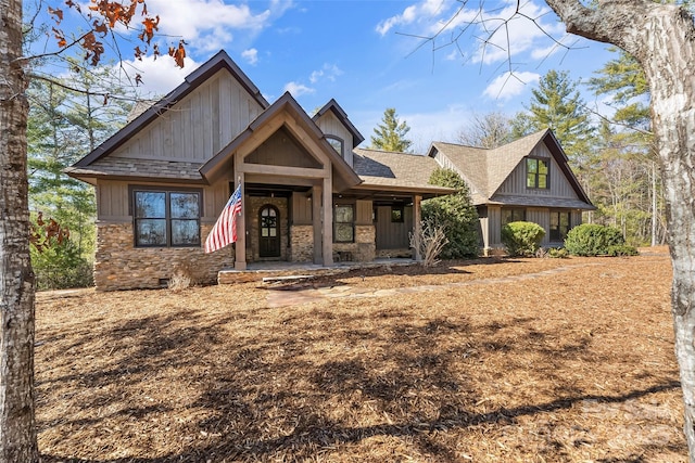 view of front facade featuring a shingled roof, stone siding, and crawl space