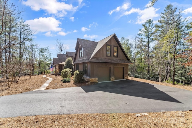 view of front of home featuring aphalt driveway, stone siding, a shingled roof, and a garage