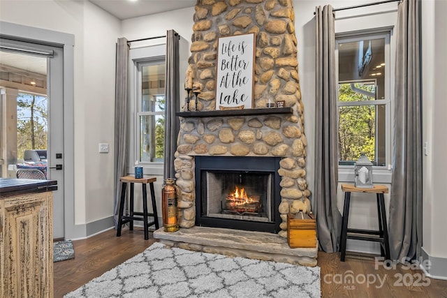 interior details with a fireplace, baseboards, and wood finished floors