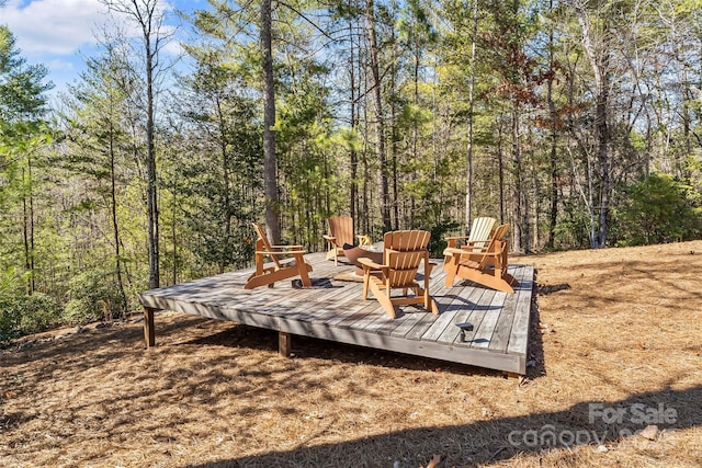 exterior space featuring a forest view and a wooden deck