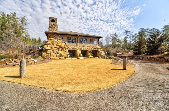 exterior space featuring a chimney and a lawn