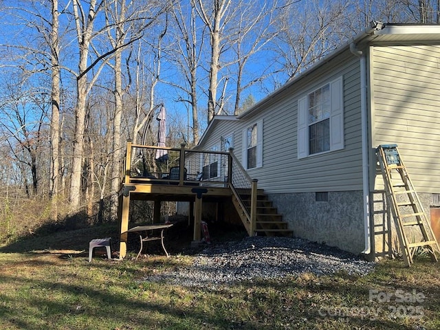 view of side of home featuring stairs and a wooden deck