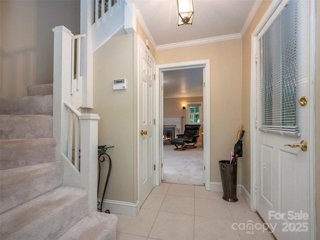 entryway featuring stairway, a warm lit fireplace, ornamental molding, and light tile patterned flooring