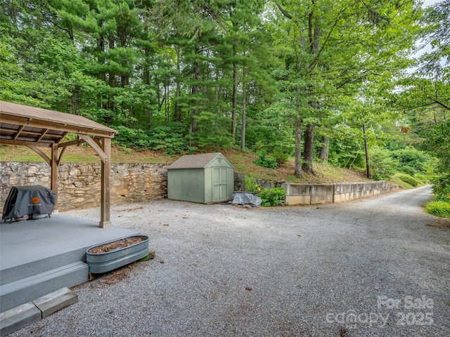 view of yard featuring a storage shed, a gazebo, a patio, and an outdoor structure