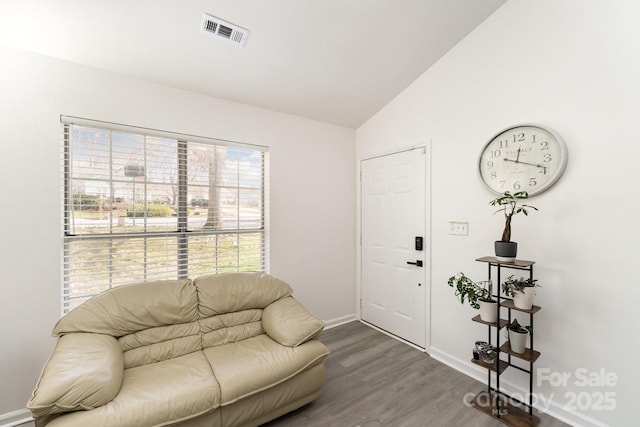 interior space featuring lofted ceiling, visible vents, baseboards, and wood finished floors