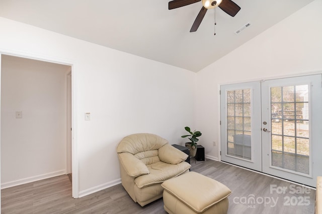 sitting room featuring lofted ceiling, wood finished floors, visible vents, baseboards, and french doors