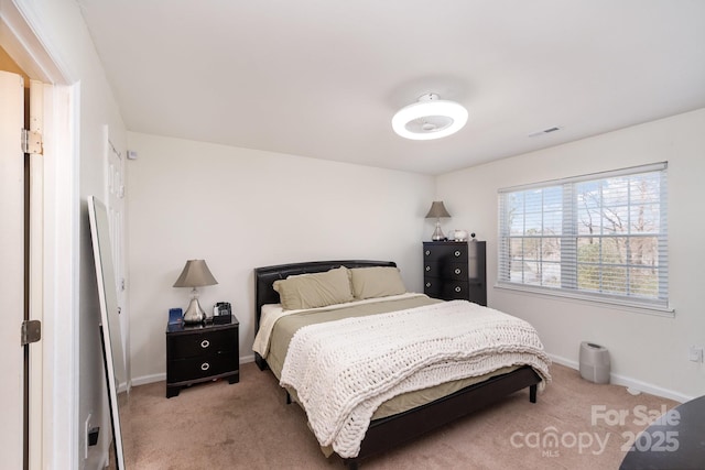 bedroom with light carpet, visible vents, and baseboards