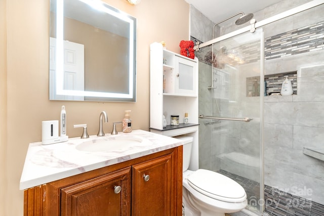 bathroom with a shower stall, toilet, and vanity