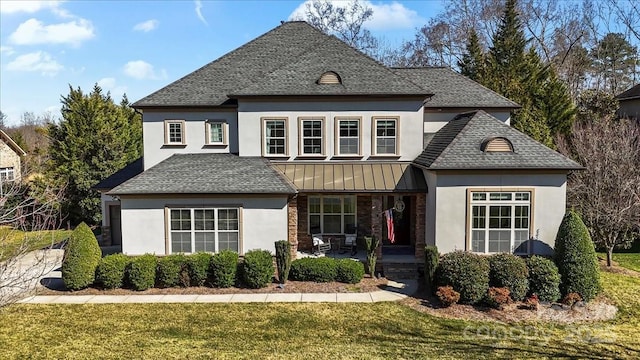 view of front of property featuring metal roof, a shingled roof, and a front yard