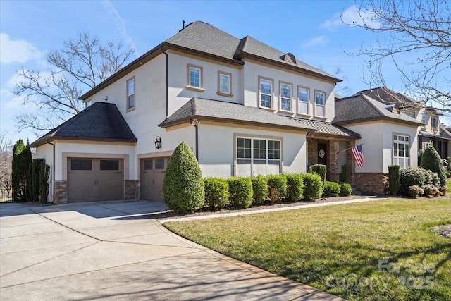 view of front of home featuring stone siding, a front lawn, concrete driveway, and stucco siding