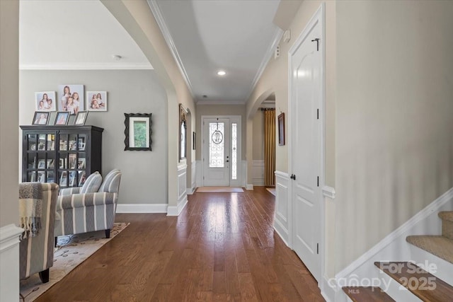 entrance foyer featuring arched walkways, crown molding, recessed lighting, stairway, and wood finished floors