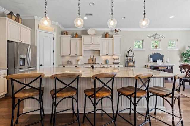 kitchen featuring light stone countertops, visible vents, decorative backsplash, and dark wood-style flooring