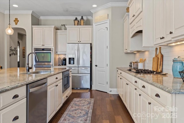 kitchen with arched walkways, stainless steel appliances, a sink, white cabinets, and dark wood-style floors