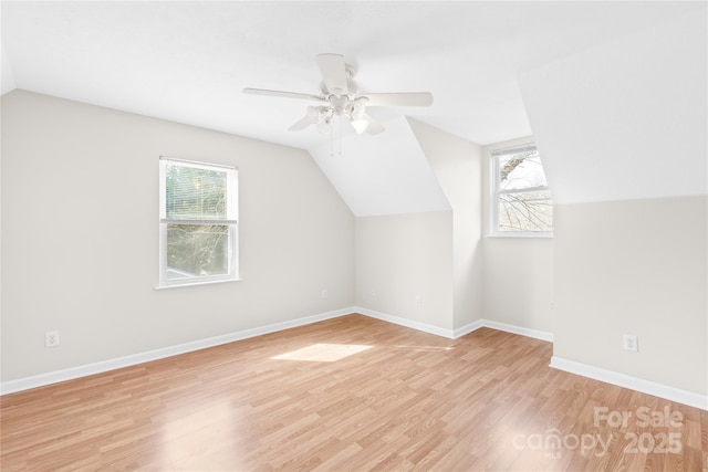 bonus room with a healthy amount of sunlight, light wood-style flooring, baseboards, and lofted ceiling