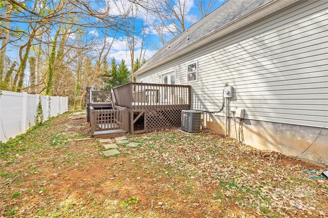 view of yard featuring cooling unit, fence, and a deck