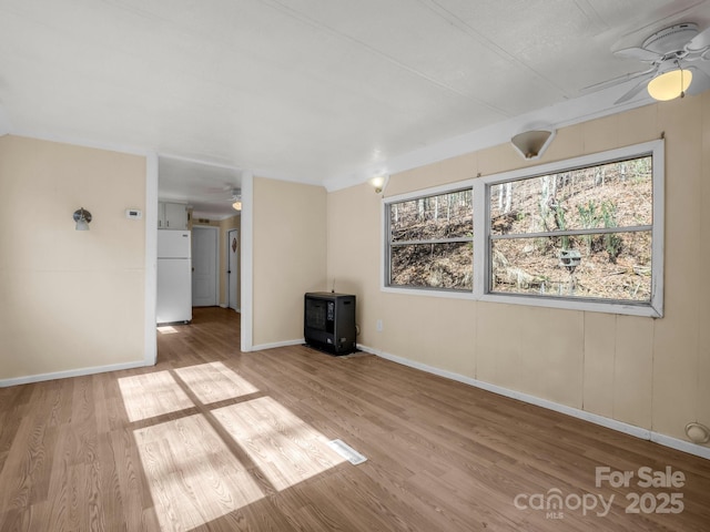 spare room with ceiling fan, wood finished floors, and a healthy amount of sunlight