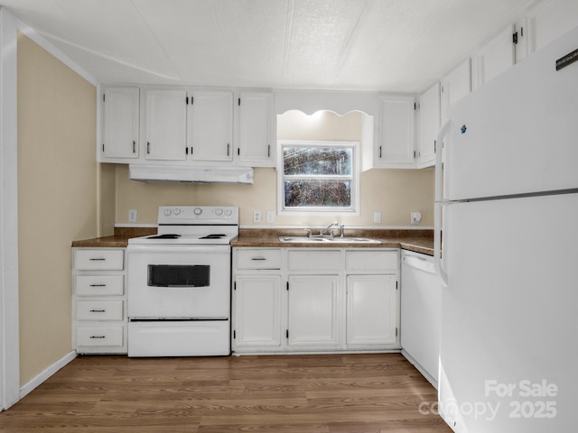 kitchen featuring dark countertops, white cabinets, a sink, white appliances, and under cabinet range hood