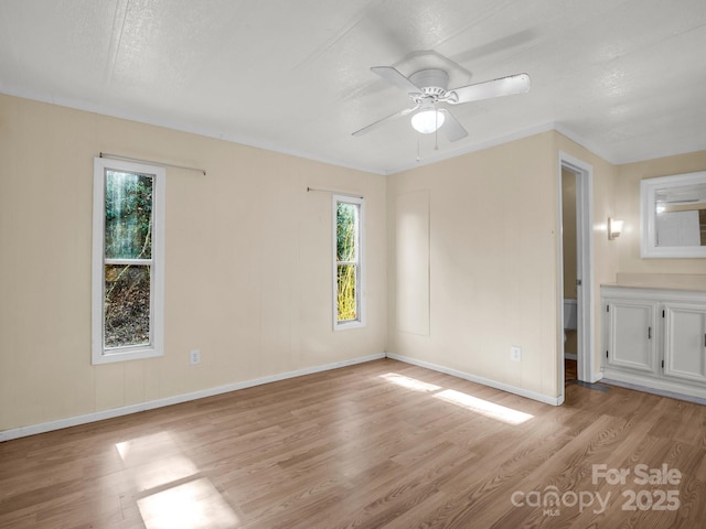 unfurnished bedroom with light wood-style floors, baseboards, and a ceiling fan