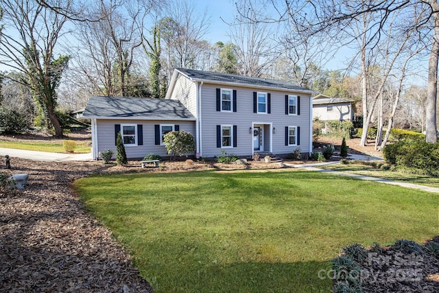 colonial-style house featuring a front yard