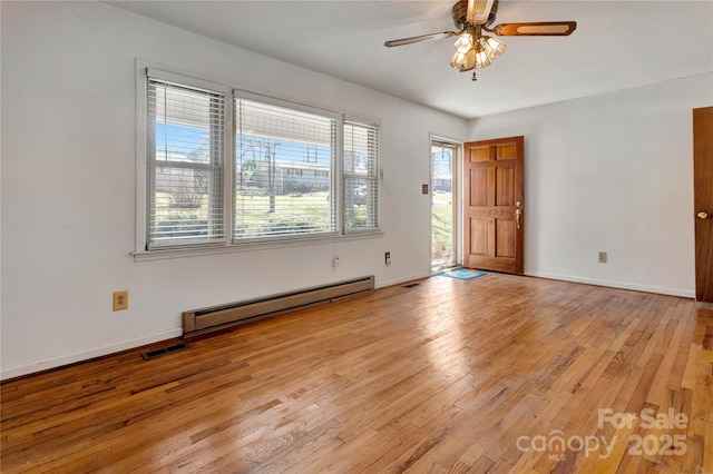 empty room with ceiling fan, visible vents, baseboards, baseboard heating, and light wood-type flooring