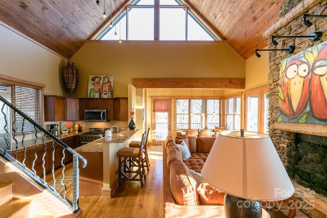 interior space featuring plenty of natural light, wood ceiling, high vaulted ceiling, and light wood-style flooring