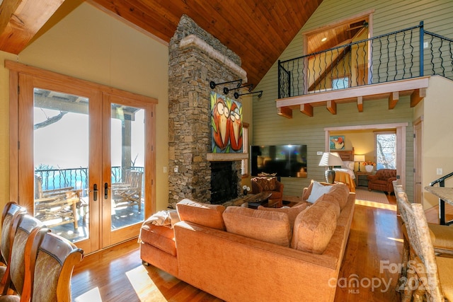 living room with high vaulted ceiling, wooden ceiling, a fireplace, wood finished floors, and french doors