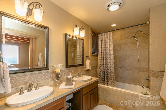 full bath featuring tiled shower / bath combo, visible vents, backsplash, and a sink