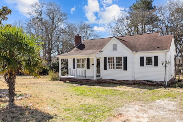 view of front of home with a chimney, a porch, a shingled roof, a front yard, and crawl space