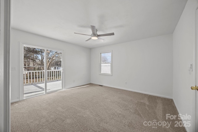 spare room featuring carpet, visible vents, baseboards, and a ceiling fan