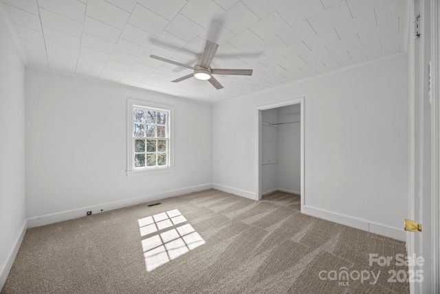 unfurnished bedroom with a ceiling fan, carpet, visible vents, and baseboards