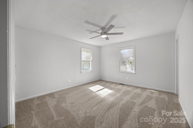 empty room with a ceiling fan, carpet flooring, and baseboards