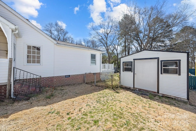 view of yard with a shed, fence, and an outbuilding