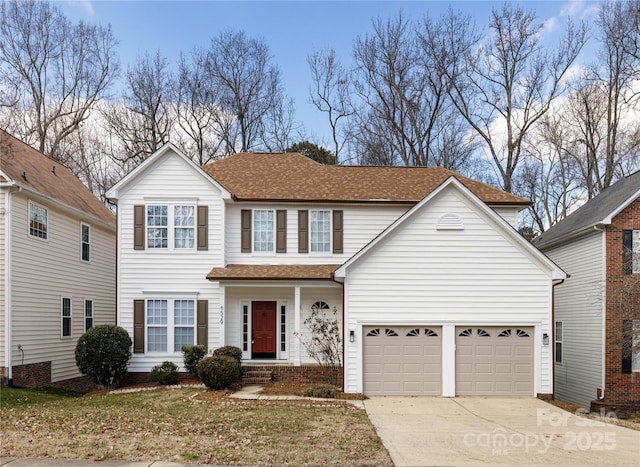 traditional home featuring an attached garage, a shingled roof, and concrete driveway