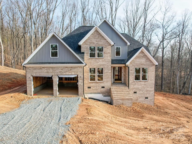 craftsman inspired home with roof with shingles, brick siding, crawl space, and driveway