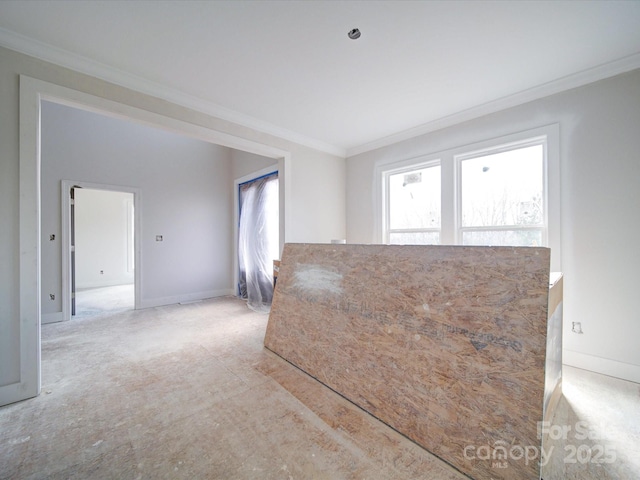 spare room with baseboards, ornamental molding, and a healthy amount of sunlight