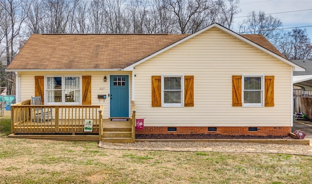 view of front of house with roof with shingles, a front lawn, and crawl space