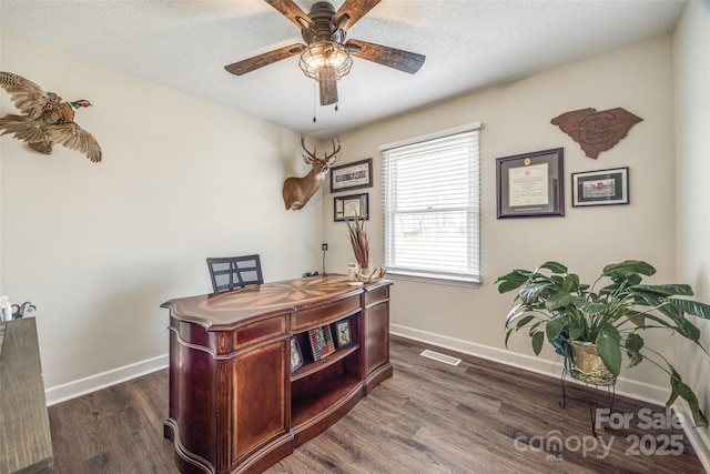 office area with baseboards, a textured ceiling, visible vents, and wood finished floors