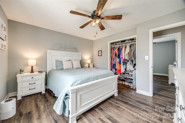 bedroom with a closet, dark wood-style flooring, independent washer and dryer, and baseboards