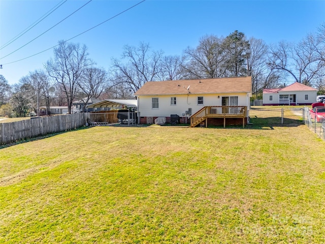 back of property with a deck, a lawn, and a fenced backyard