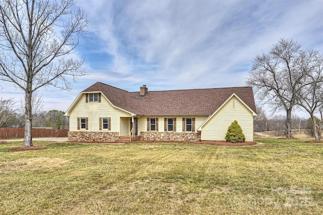 view of front facade featuring stone siding, a chimney, a front yard, and fence