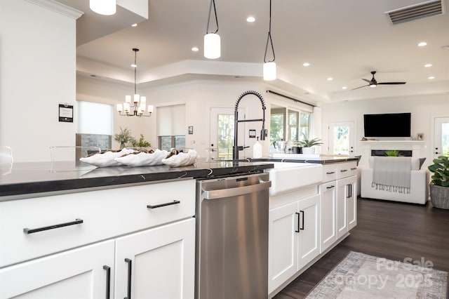 kitchen featuring open floor plan, a tray ceiling, stainless steel dishwasher, and visible vents