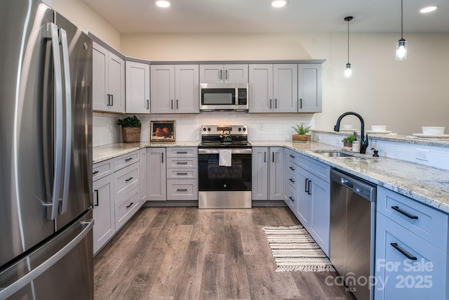 143 Carver St Unit 16, Brevard, NC 28712 - kitchen featuring stainless steel appliances, a sink, dark wood finished floors, light stone countertops, and hanging light fixtures